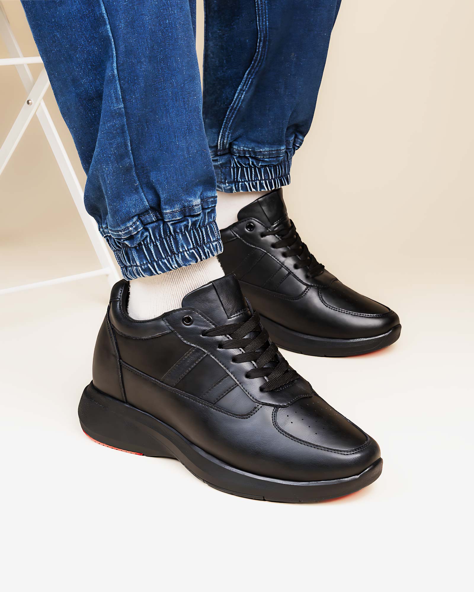 Lifestyle model wearing Hitoes Altix Trio black height increasing sneakers with 3 inches hidden lift