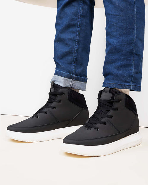 Lifestyle model wearing Hitoes Cavario black height increasing sneakers with 3 inches hidden lift