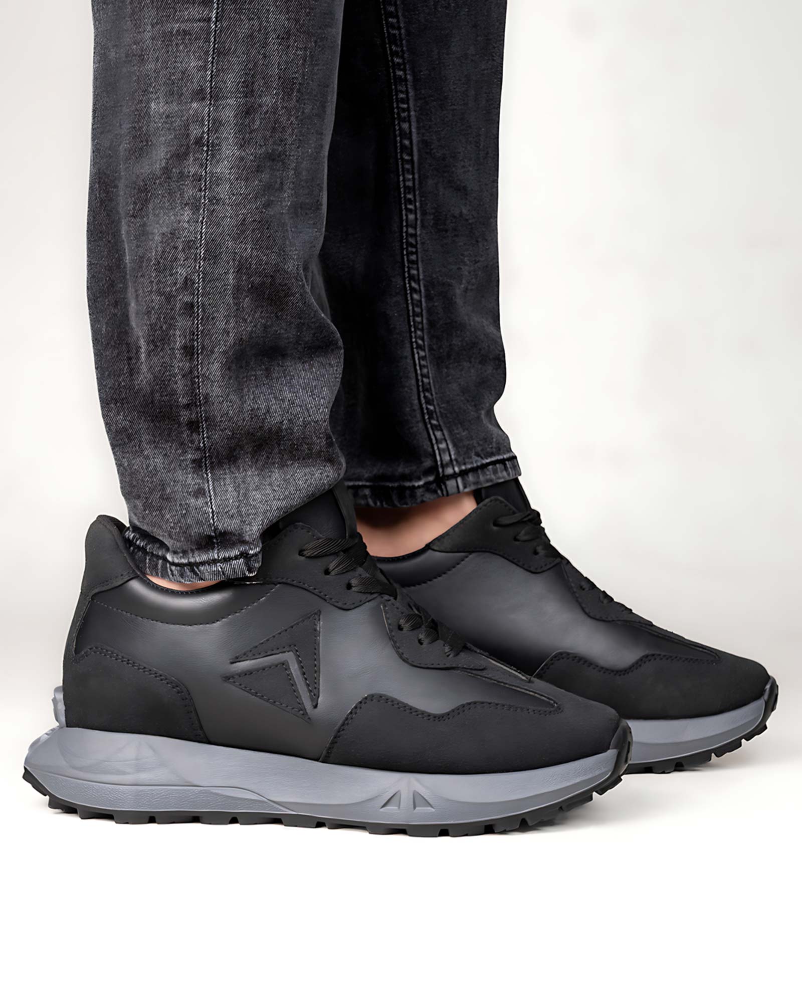 Lifestyle model wearing Hitoes Orren black height increasing sneakers with 3 inches hidden lift